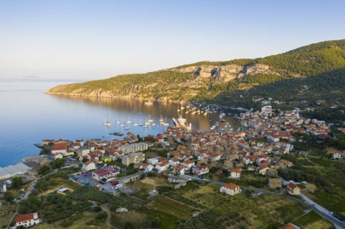 aerial-view-komiza-town-vis-island-croatia-dalmatia-sunrise-city-laying-seaside-mediterranean-sea-surrounded-by-hills-summer-vacation-season